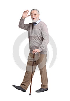 Senior man with walking cane waving on white background