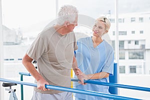 Senior man walking with therapist help