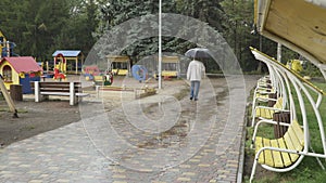 Senior man walks in rainy park