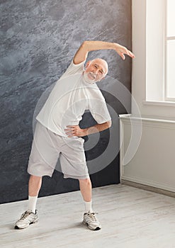 Senior man warmup stretching training indoors