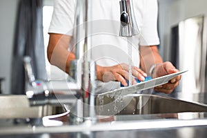 Senior man washing dishes in his  kitchen