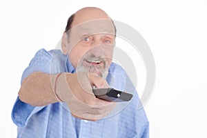 Senior man watching tv with remote control