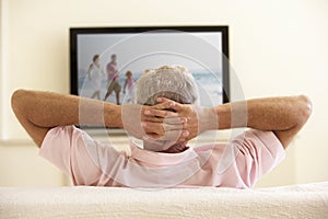 Senior Man Watching Widescreen TV At Home