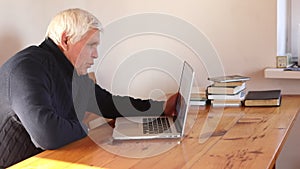 Senior man waving hand holding digital tablet computer video conference calling
