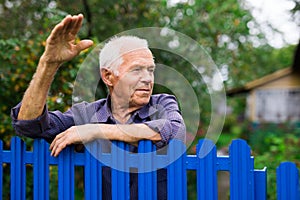 Senior man waving with hand outdoors