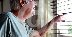 Senior man waving his hand from window