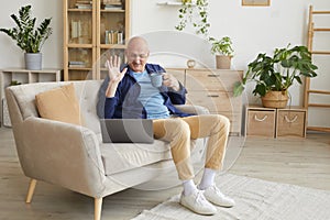 Senior Man Waving for Video Call at Home