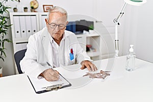 Senior man wearing doctor uniform doing rorscharch test at clinic