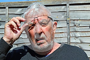 Senior man wearing spectacles glaring towards camera photo
