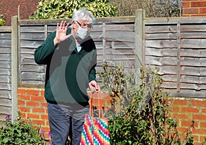 Senior man wearing face mask, waving. Corona.