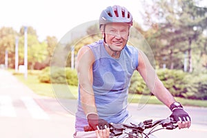 Senior man wearing helmet while riding bicycle in park