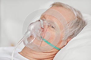 Senior Man wearing Oxygen Mask in Hospital