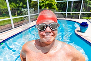 Senior man wearing swimming cap and goggles