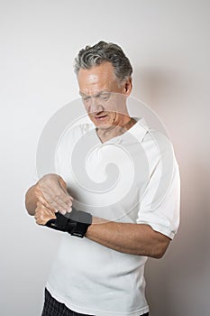 Senior Man wearing a wrist brace on his left hand and wrist