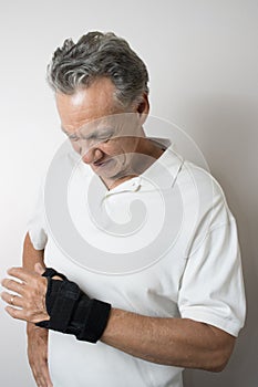 Senior Man wearing a wrist brace on his left hand and wrist