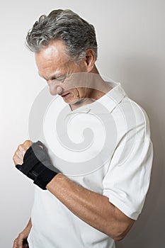 Senior Man wearing a wrist brace on his left hand and wrist