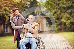 Senior man in wheelchair with caregiver daughter