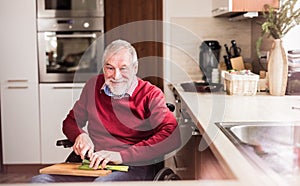 Senior man in wheelchair cooking in the kitchen.