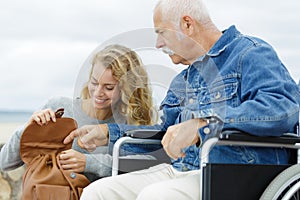 Senior man in wheelchair and daughter in park