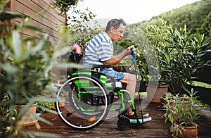 Senior man in wheelchair doing exercise on terrace.