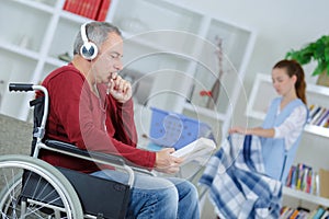 Senior man in wheelchair with help carer