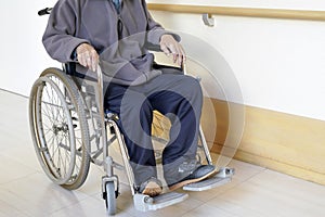 Senior man in wheelchair at hospital hallway