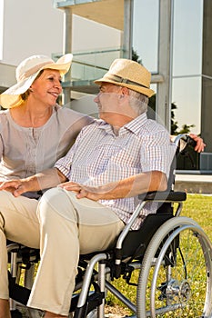 Senior man in wheelchair smiling on his wife