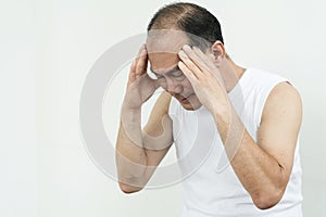 Senior man in white shirt having headache from stress and migraine while working out with white background.