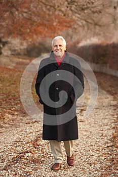 Senior Man On Winter Walk Through Frosty Landscape