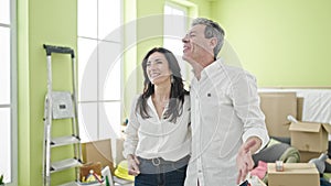 Senior man and woman couple hugging each other kissing at new home