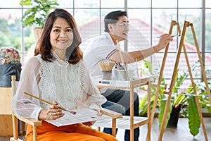 Senior man and woman couple, husband and wife, painting image together in home gallery with warm and happy circumstance. Idea for