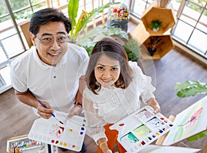 Senior man and woman couple, husband and wife, painting image together in home gallery with warm and happy circumstance. Taken