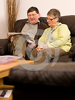 Senior man and woman couple reading newspaper