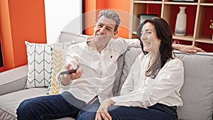 Senior man and woman couple smiling confident watching television at home