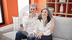 Senior man and woman couple smiling confident watching television at home