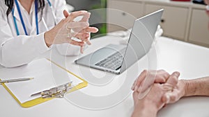 Senior man and woman doctor and patient having medical consultation looking laptop at clinic