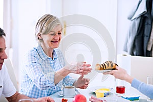 Senior man and woman having breakfast. Sunny morning.