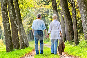 Senior man and woman holding hand walking