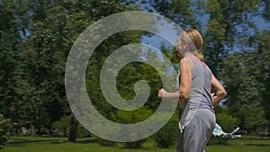 Senior man and woman jogging in park, health care, active people slow-motion