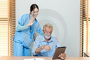 Senior man and woman making online call using tablet. Nurse Helps Senior man Video Chat On Tablet In Nursing Home Or At Home