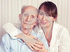 Senior man, woman with their caregiver at home.