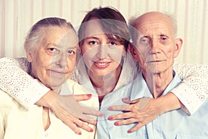 Senior man, woman with their caregiver at home.