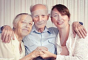 Senior man, woman with their caregiver at home.