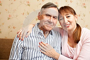 Senior man, woman with their caregiver at home.