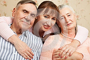 Senior man, woman with their caregiver at home.