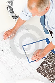 Senior man work on blueprints construction plans