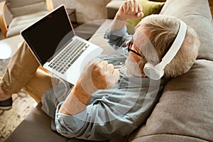 Senior man working with laptop at home - concept of home studying