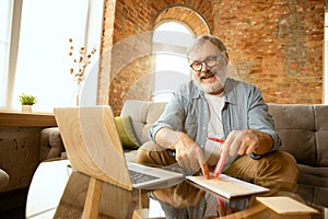 Senior man working with laptop at home - concept of home studying