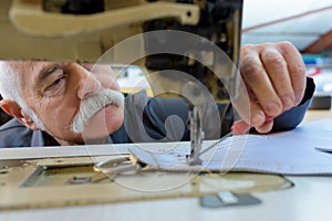 Senior man working with old-sewing machine