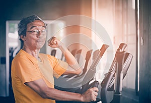 Senior man is working out in fitness gym with confidence muscle show off